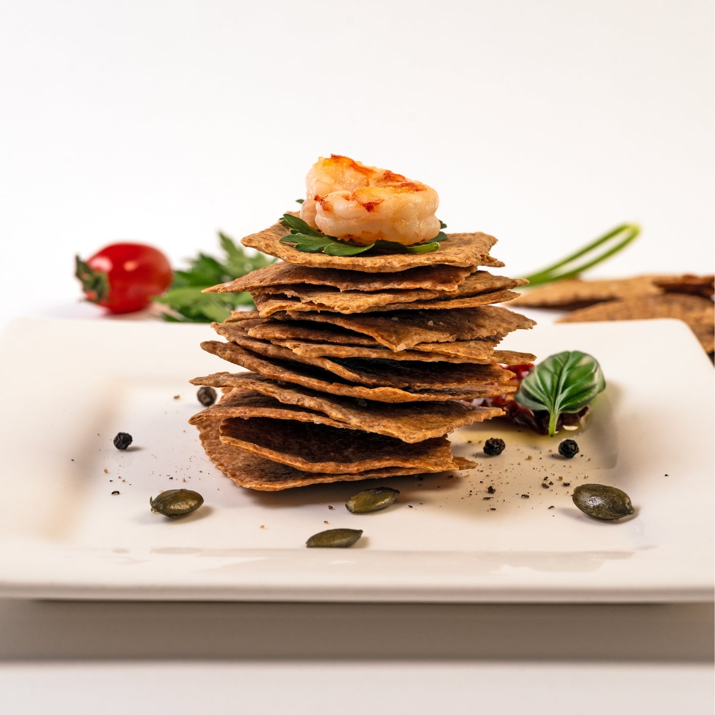
                  
                    Gourmet stack of Revival Einkorn Roasted Garlic & Chile Snack Crackers with garnish
                  
                